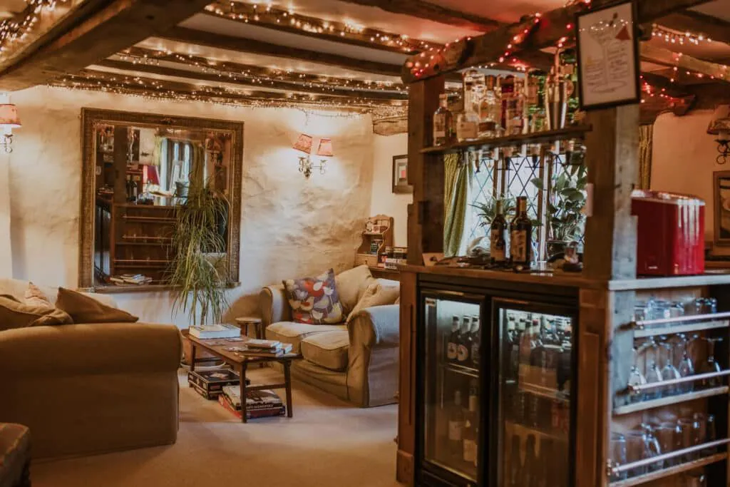 Bar & Lounge: sofas, fairy lights and a bar with a mirror above the fire